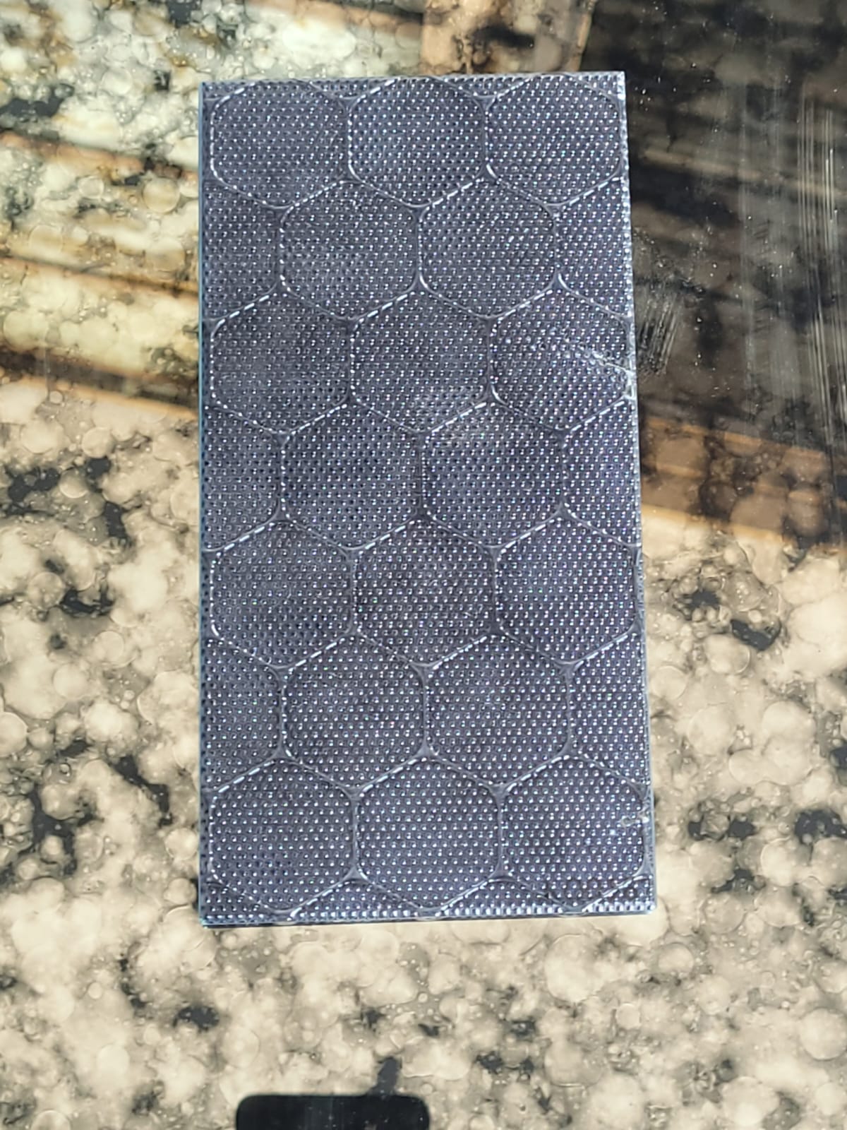 Dark honeycomb glass — A small dotted texture arranged in dark hexagons.