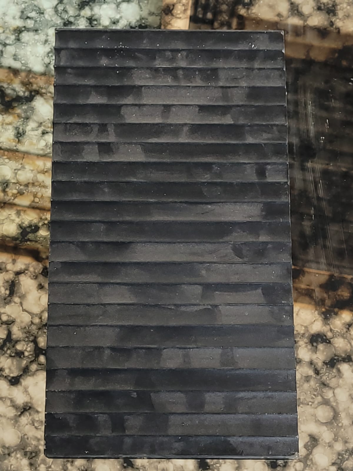 Dark linear glass — Stacked horizontal lines in a dark finish.