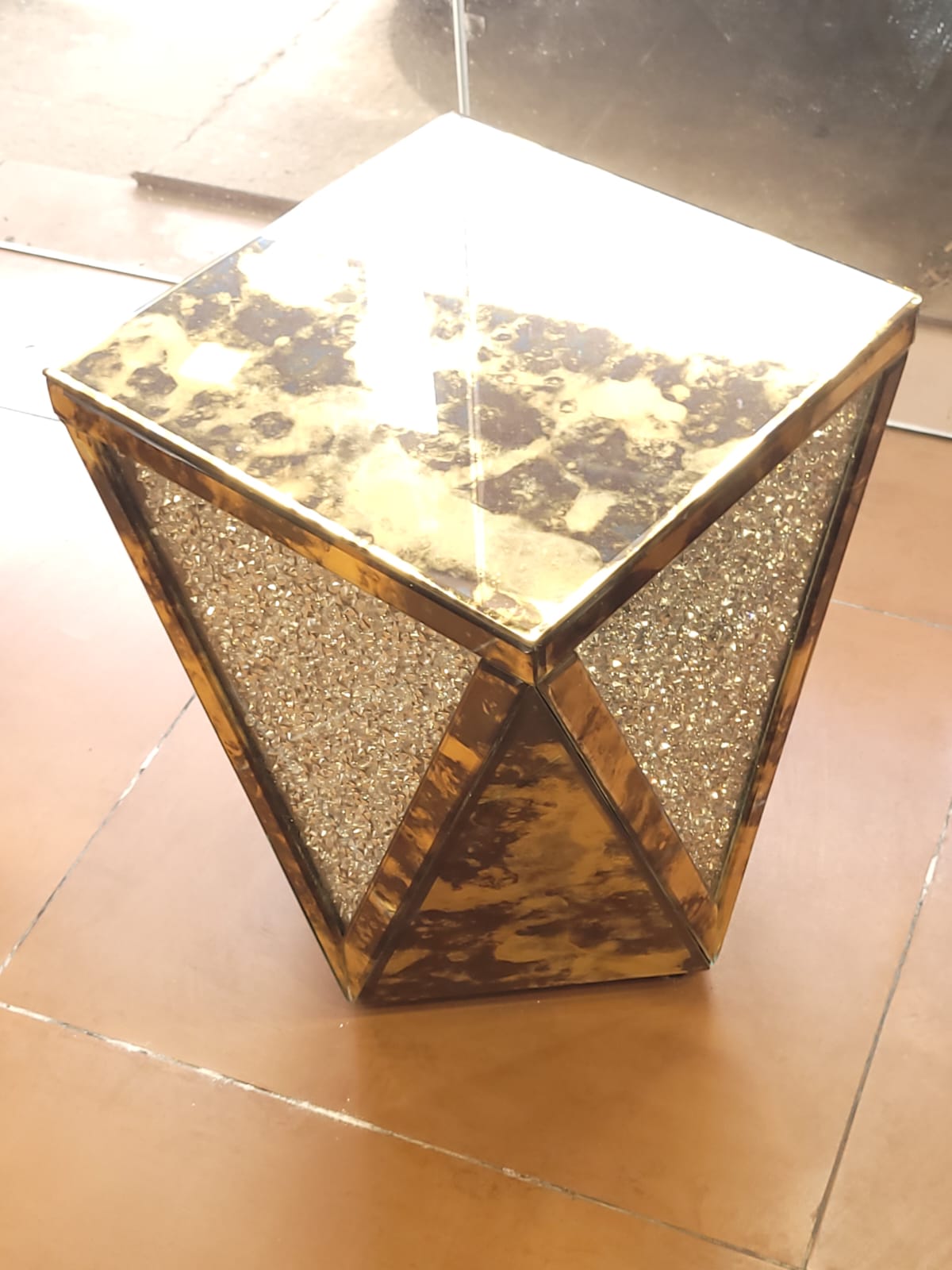 Faceted mirrored side table — A faceted table with mirrored and sparkling triangular surfaces.