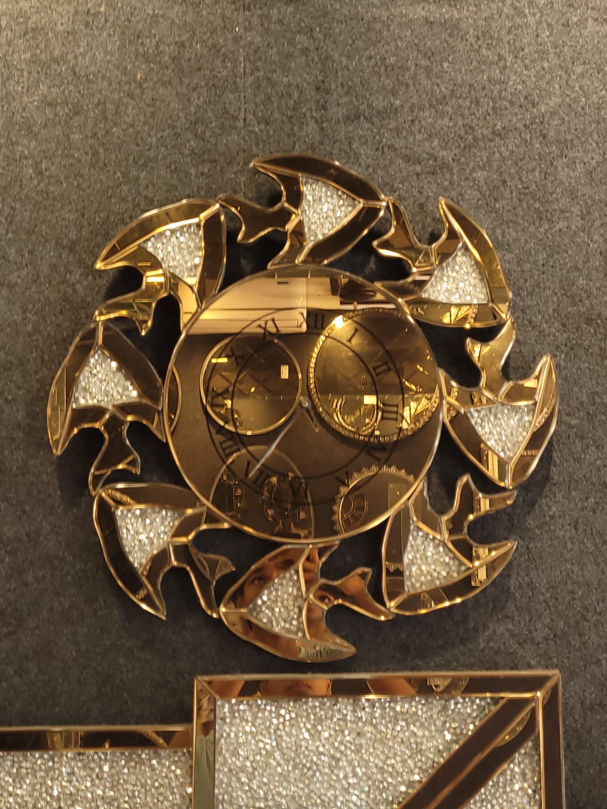 Curved-petal mirrored clock — Curved, sparkling petals encircle a gold-toned clock face.