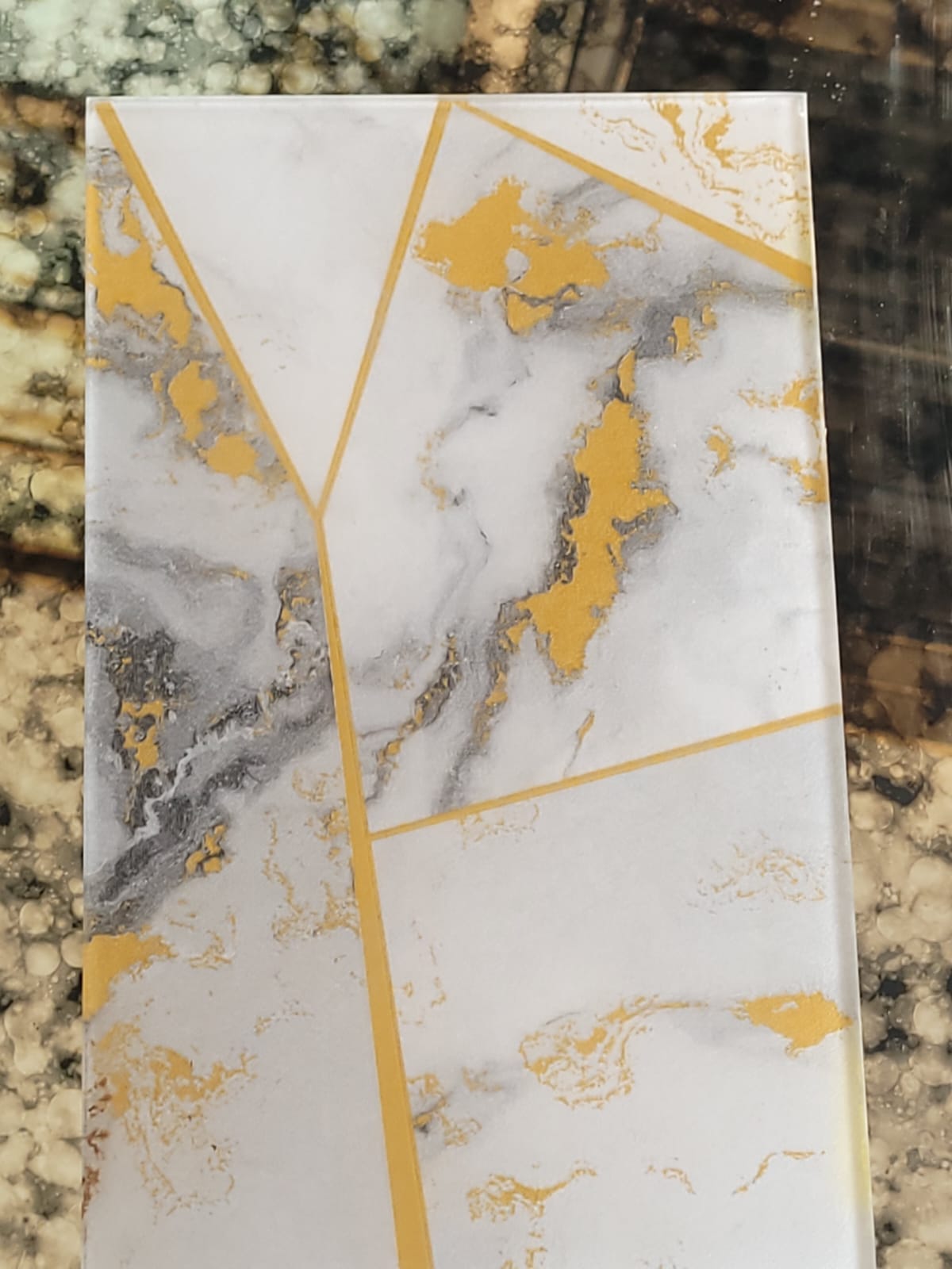 Marble-effect glass — A pale marble-effect design crossed by gold lines.