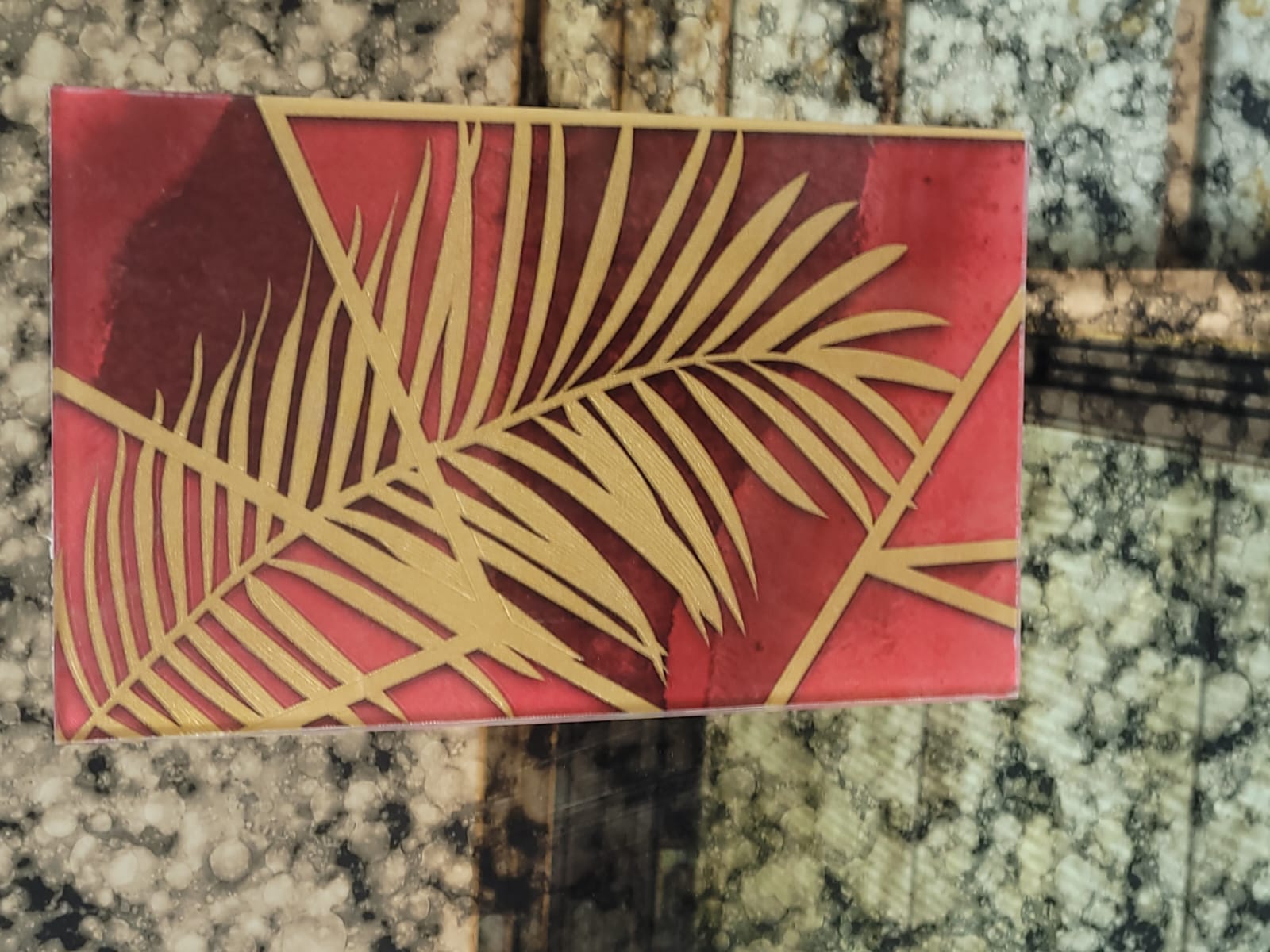 Palm-leaf glass — Gold palm leaves set against a deep red background.