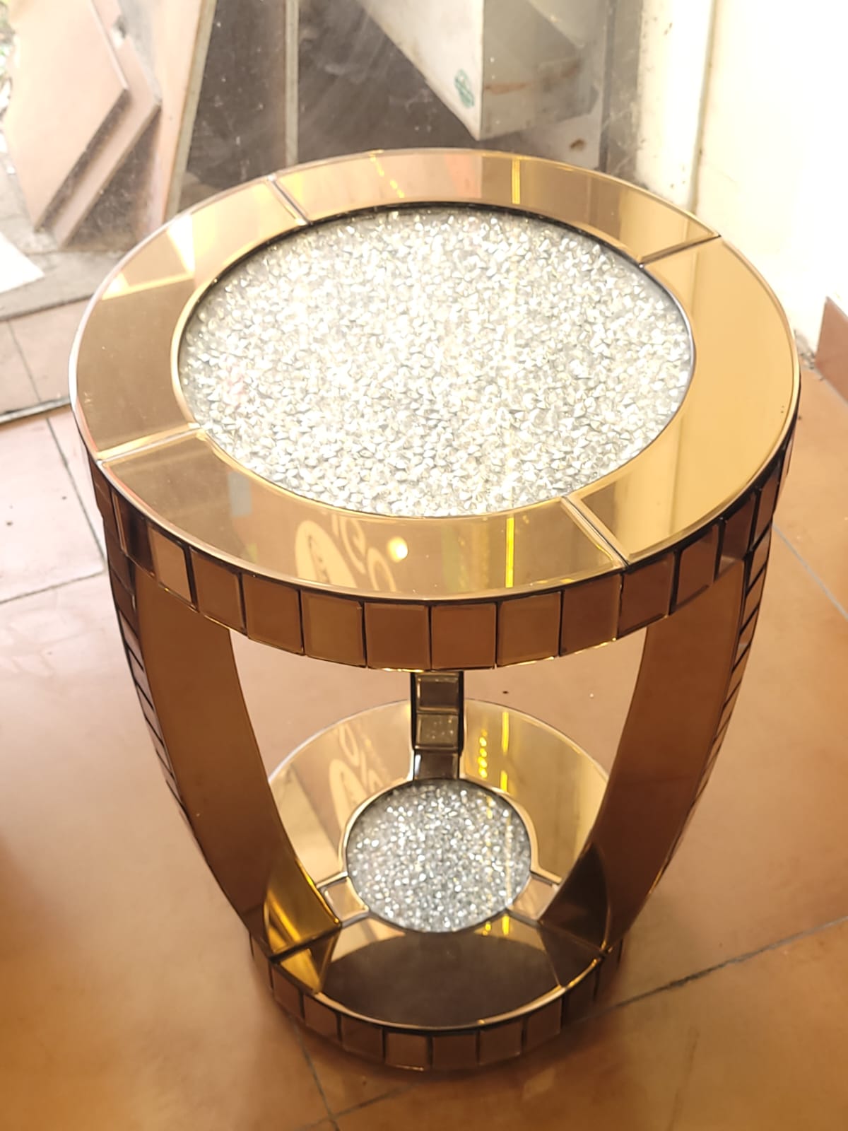 Round mirrored side table — A round side table with a mirrored base and sparkling inset surfaces.