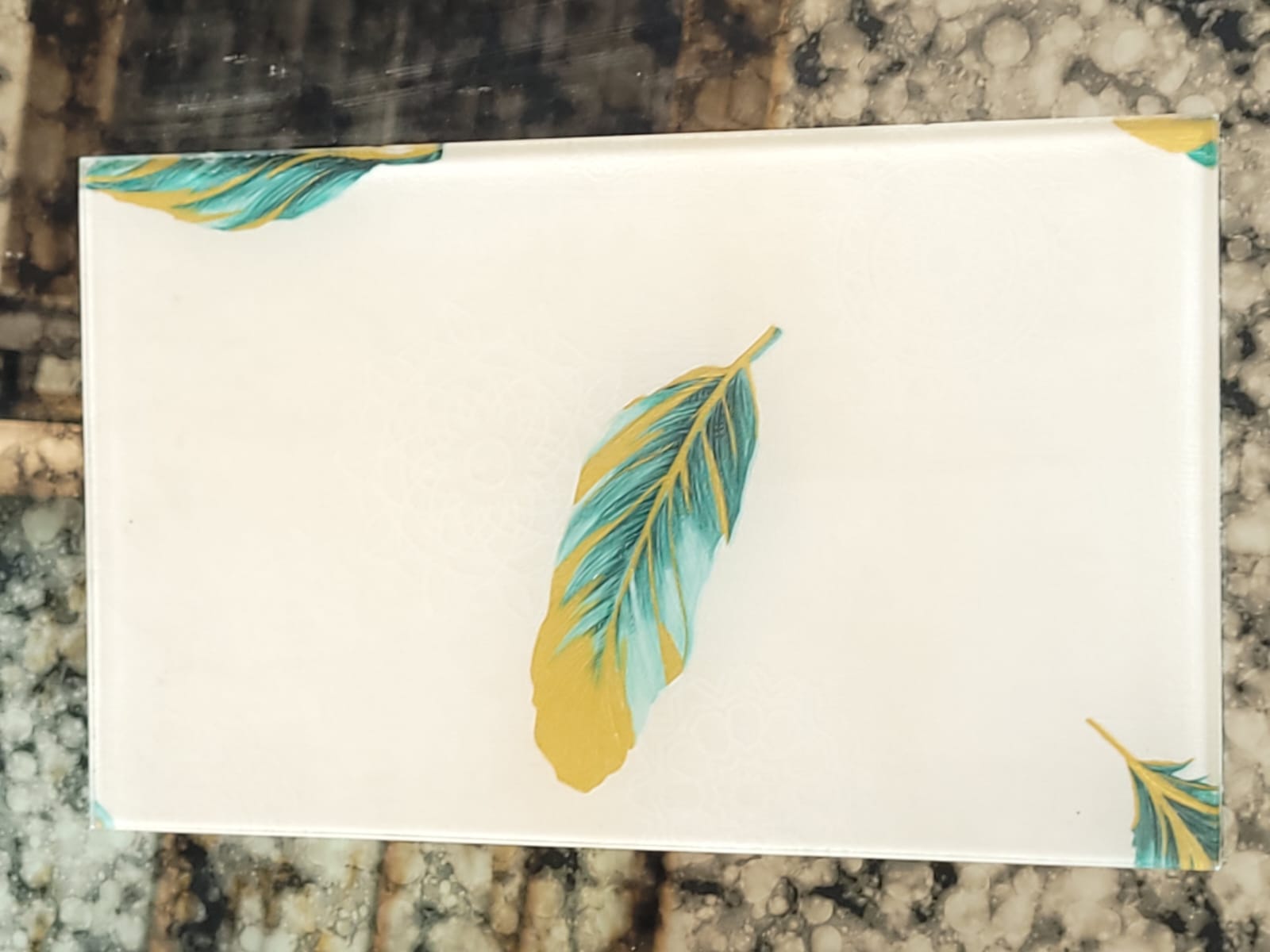 Feather-print glass — Teal and gold feather accents on an ivory ground.