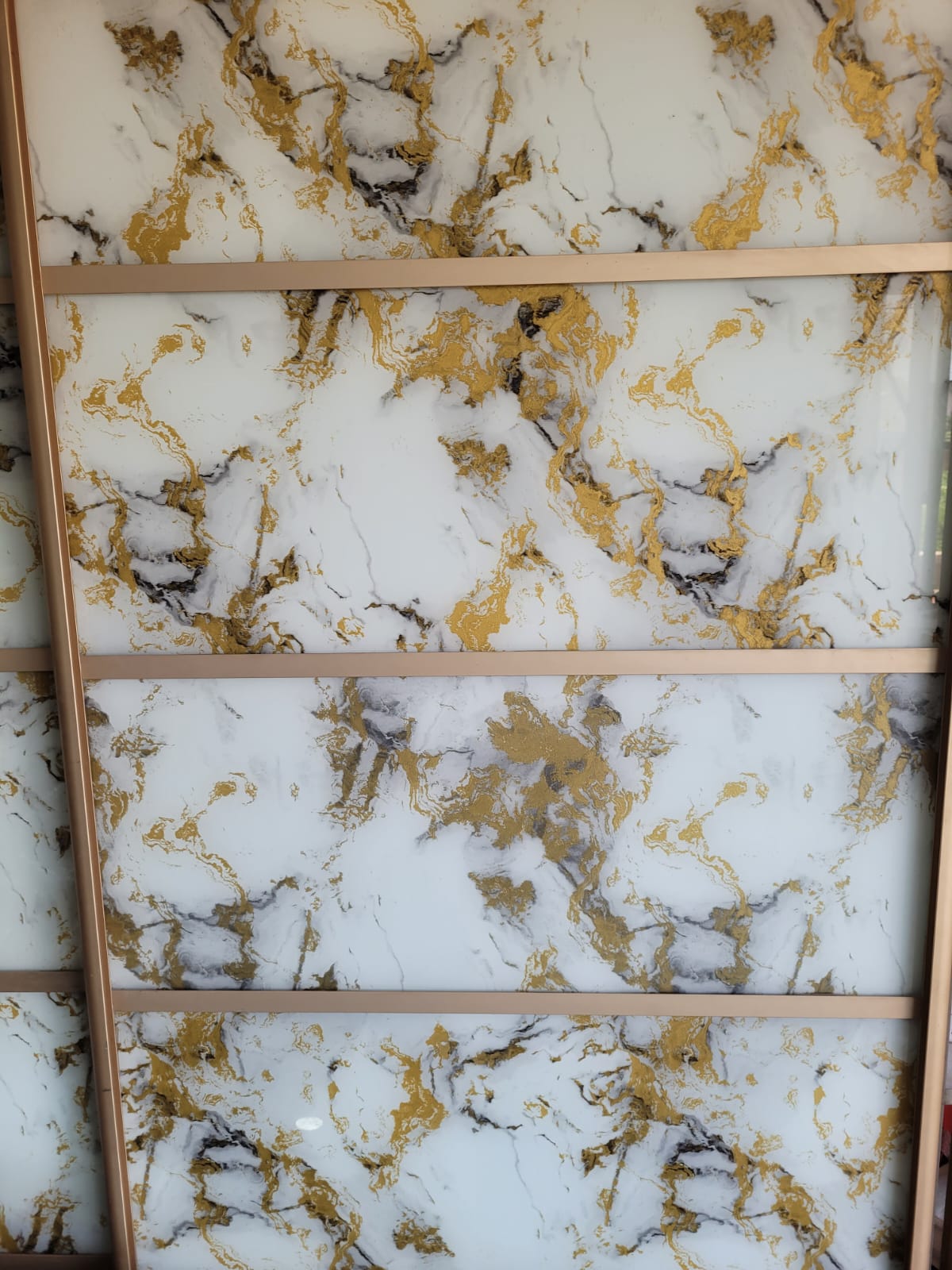 Marble-effect display panel — White and gold marble-effect glazing in a full-height display.